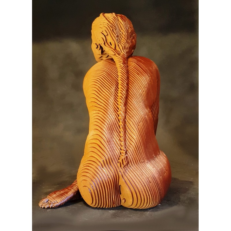 Femme assise réalisé par Olivier Duhamel en lamellé-collé de bois, explore la forme humaine par la lumière et les volumes.